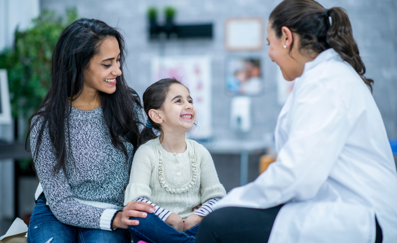 Child with mom is looking up at doctor confidently. LifePath prepares kids and teens to understand their one body for life.