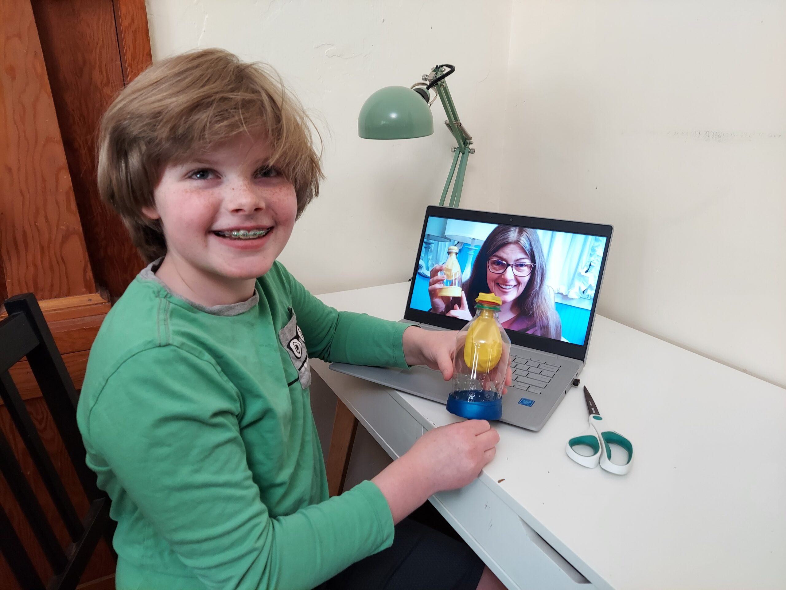 Student sitting at a laptop where Dr. Robin is demonstrating and student is doing physician led science curriculum for kids