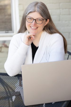Dr. Robin welcomes partnership with other professionals, with families, and with organizations. Here she's sitting at her computer smiling at the camera, presumably looking forward to connecting with the viewer.